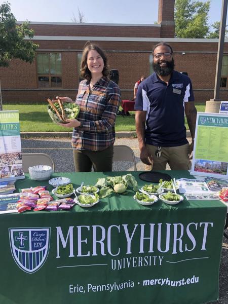 ܼˮ̳ staff handing out produce at a community event